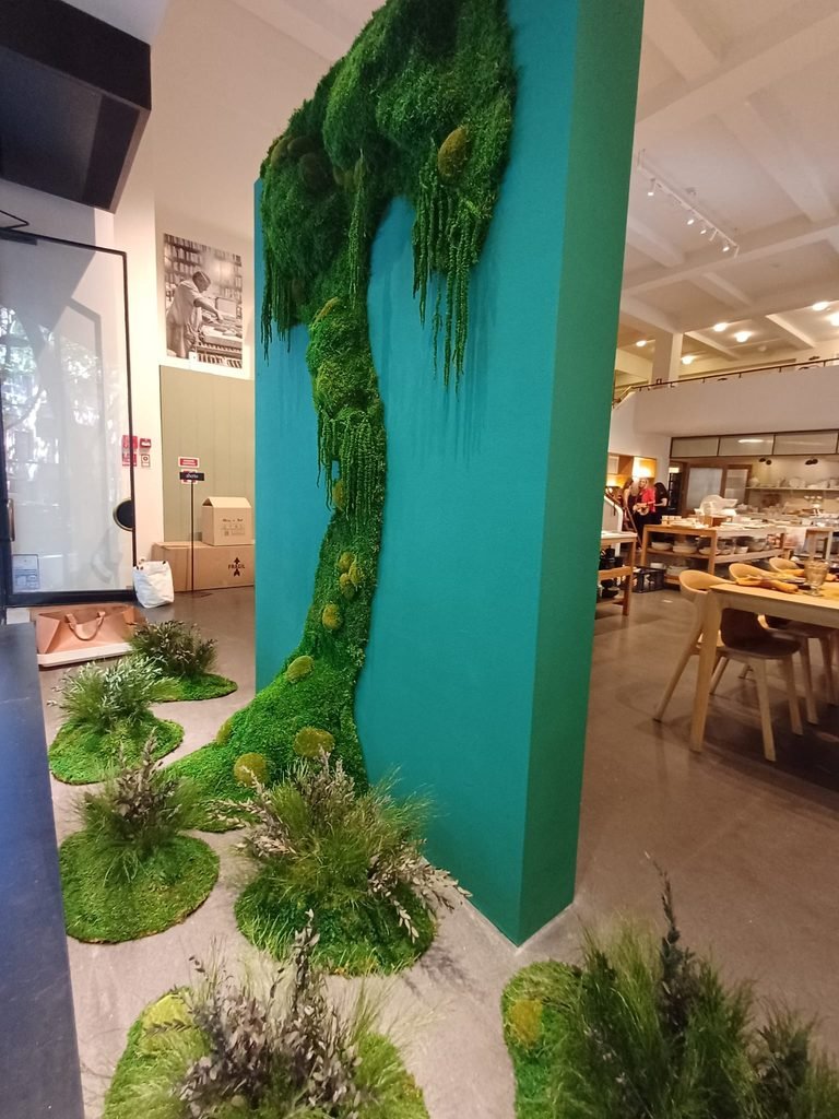 Detalhe do design orgânico com musgo preservado a escorrer pelo painel turquesa na vitrine da loja Costa
Nova, sem necessidade de rega.